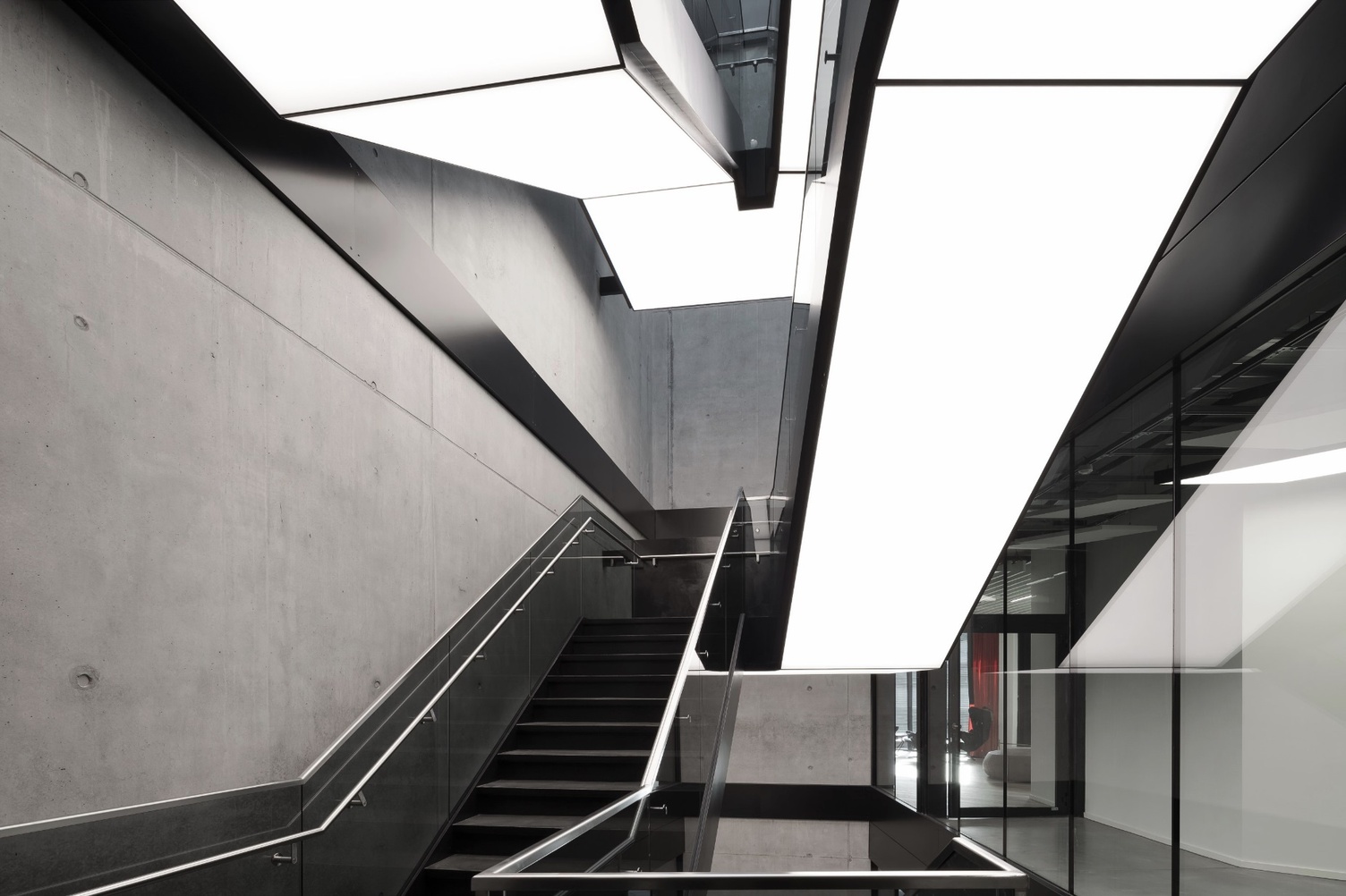 Individuelle Lichtdecke – AMG Maßgeschneiderte geometrische Lichtdecke über einem modernen Treppenhaus bei AMG