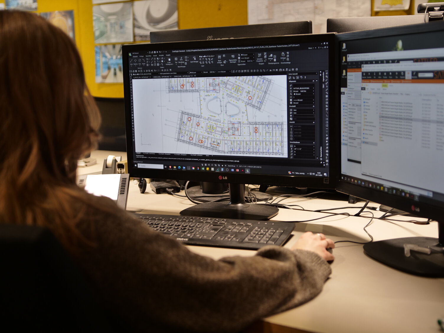SATTLER Lichtplanung: Kollegin arbeitet mit DIALux SATTLER Kollegin arbeitet mit DIALux-Lichtplanungssoftware am Grundriss